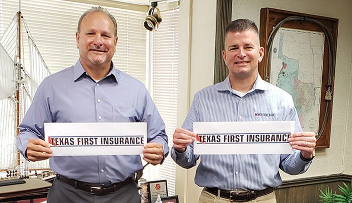 Two men holding 'Texas First Insurance' signs