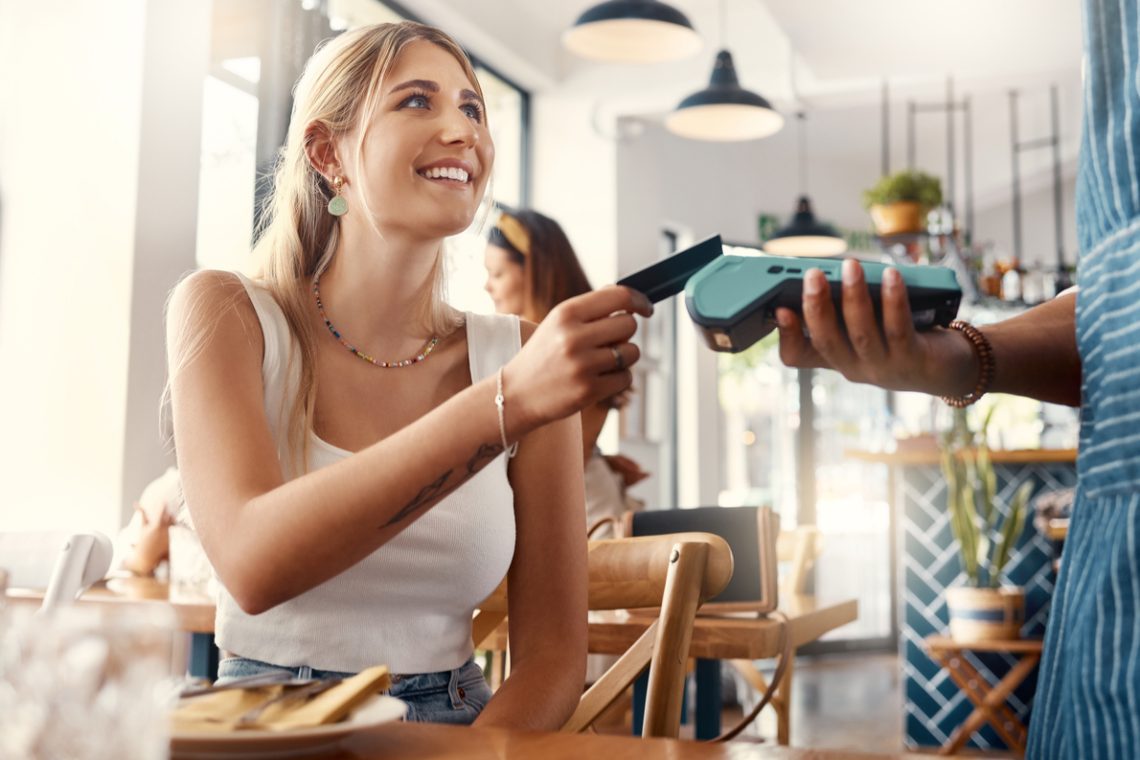 Young woman paying with secured credit card